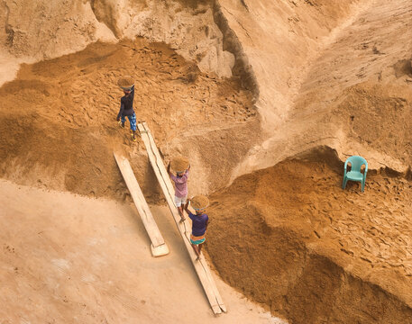 Aerial view of workers unloading sand into baskets at a construction site, Darus Salam Thana, Dhaka, Bangladesh.