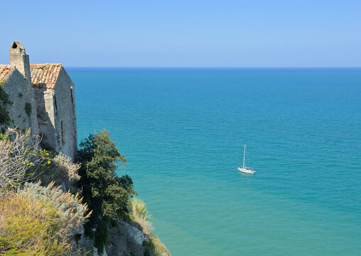 Picturesque high-angle view of the blue ocean under town of Peschici, Gargano, by a road trip from Vieste to Lago di Lesina. Travel Photography in Apulia (Puglia) in summer/fall. Copy space for text.