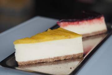 Delicious cheesecake slices with fruity toppings on a tray