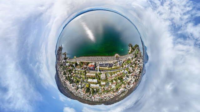 Aerial view of a tiny planet cityscape with a beautiful lake, clouds, and buildings, Neuchatel, Neuchatel, Switzerland.