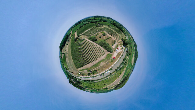 Aerial view of a tiny planet featuring beautiful vineyards and green fields in a picturesque rural landscape, Capestang, Herault, France.