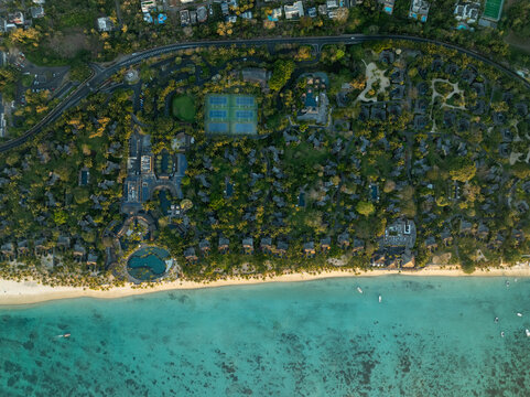 Aerial view of beautiful tropical beach and luxury resort with clear blue ocean and green forest, Trou aux Biches, Pamplemousses, Mauritius.