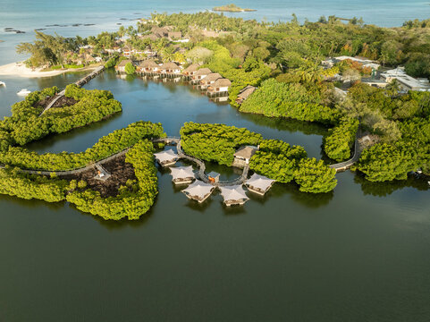 Aerial view of luxurious island resort with bungalows and serene lagoon surrounded by tropical greenery, prince maurice, flacq, mauritius.