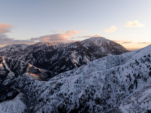 Aerial view of majestic snowcapped mountains at sunset with dramatic clouds, Sundance, Utah, United States.