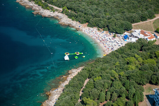Aerial view of ambrela beach with clear turquoise water and sandy coastline, Pula, Istria, Croatia.