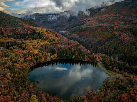 Aerial view of maple lake surrounded by colorful autumn foliage and majestic mountains, Payson, Utah, United States.