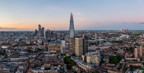 Aerial view of the modern shard skyscraper amidst a vibrant cityscape at dusk with the River Thames, Southwark, England, United Kingdom.