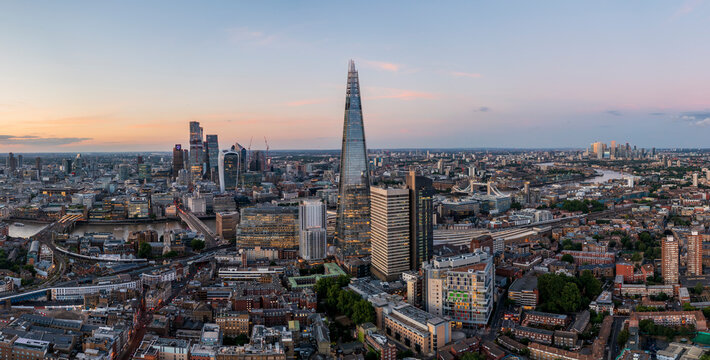Aerial view of the modern shard skyscraper amidst a vibrant cityscape at dusk with the River Thames, Southwark, England, United Kingdom. - Powered by Adobe