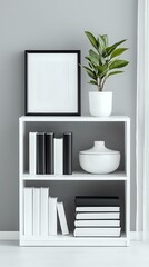 Minimalist white bookshelf with black frame mockup, books, ceramic vase and green plant against gray wall. Modern scandinavian home decor styling.