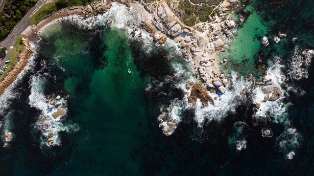Aerial view of abstract coastal waves crashing against rocks along the shoreline, Millers Point, Simon's Town, Western Cape, South Africa.