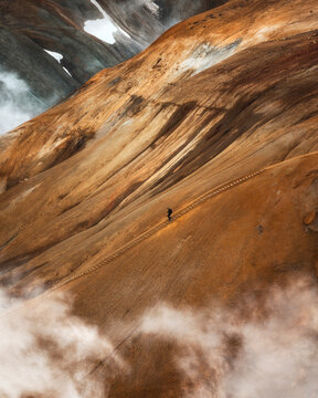 Aerial view of rugged mountains and a hiking trail surrounded by clouds in the serene highlands of Iceland, Kerlingarfjoll, Iceland.