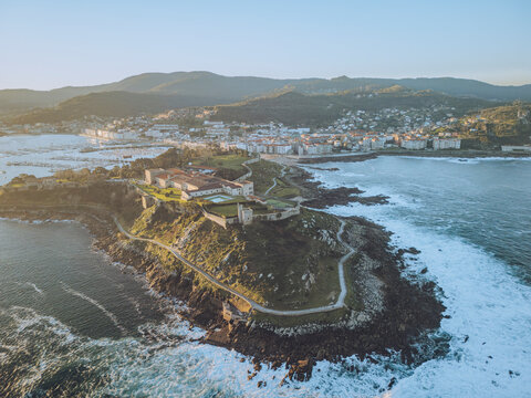 Aerial view of the historic fortaleza de monterreal overlooking the beautiful coastline and rocky cliffs with waves crashing, Baiona, Pontevedra, Spain.