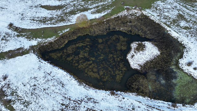 Aerial view of tranquil frozen lake surrounded by beautiful snow-covered landscape, Posof, Ardahan, Turkiye.