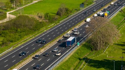 Aerial view of an Italian highway. There is a lot of traffic of cars and trucks.