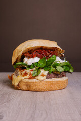 Panino pub con hamburger di carne, songino fresco, provola affumicata, stracciata di bufala e pomodori secchi servito in un pub