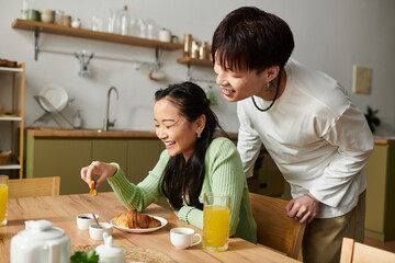Joyful morning together as a young couple enjoys breakfast at home