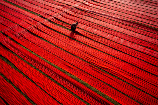Aerial view of colorful fabric drying in rows at a traditional textile workshop, Paikar Char, Narsingdi, Dhaka, Bangladesh.