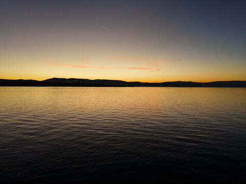 Aerial view of serene sunset over calm water and picturesque coastline, Cres Island, Primorje-Gorski Kotar, Croatia.