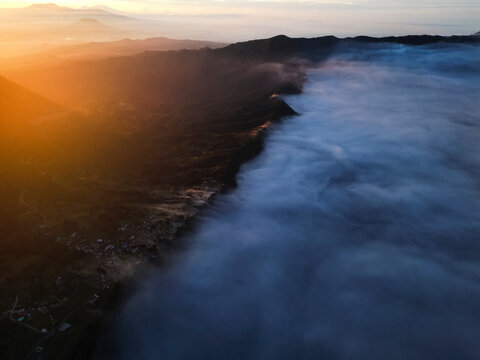 Aerial view of majestic Java Volcano at sunrise surrounded by fog and mist, Sukapura, Probolinggo, East Java, Indonesia.