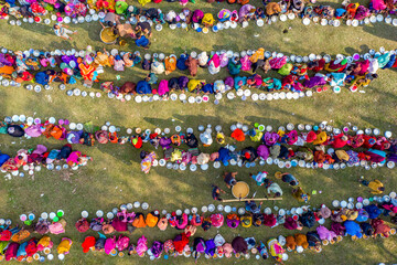Aerial view of a vibrant majlis public food offering with a large crowd celebrating in colorful clothing, Saidpur, Rajshahi, Bangladesh.