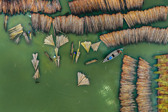 Aerial view of jute retting with traditional wooden boats on a serene river, Piprul, Natore, Rajshahi, Bangladesh.