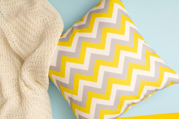 Pillow with zigzag pattern with textile plaid on blue background