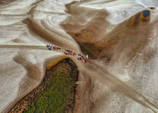Aerial view of people crossing a scenic sandbar amidst a beautiful natural landscape, Kanchi Para, Phulchhari, Rangpur, Bangladesh.