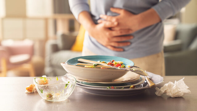 Woman with bloating and stomach ache from overeating