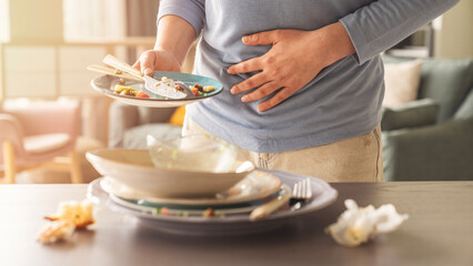 Woman with bloating and stomach ache from overeating