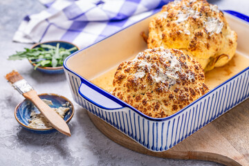 Whole baked cauliflower with truffle butter in a casserole