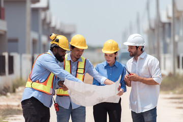 Group of architects and engineers work together to assess the residential home construction site's...