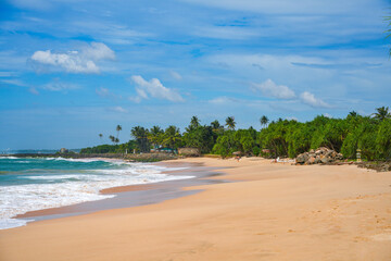 Koggala beach with blue cloudy sky and foamy waves, Koggala, Sri Lanka, Asia