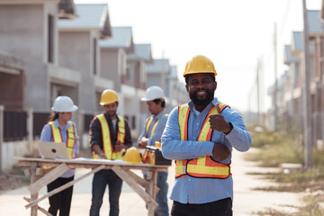 Portrait of engineers work together to assess the residential home construction site's progress