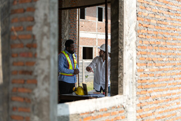 Architects and engineers work together to assess the residential home construction site's progress