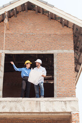 Architects and engineers work together to assess the residential home construction site's progress