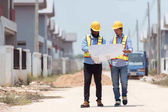Architects and engineers work together to assess the residential home construction site's progress