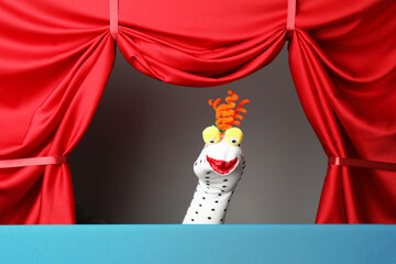 Creative puppet show on stage with red curtains