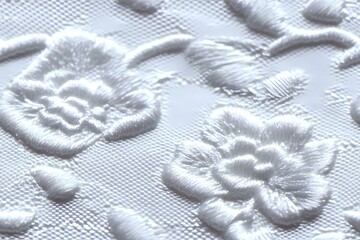 Delicate white embossed floral pattern on textured fabric surface creates elegant relief design with raised flowers and leaves, showing subtle shadows and depth.