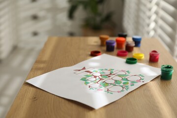Family tree and paints on wooden table