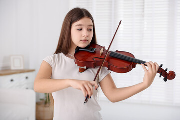 Teenage girl playing violin at music lesson