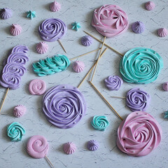 Top view of multi-colored meringue curls of different shapes on a gray marble background. Flat lay for confectionery