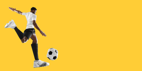 Man, soccer player in white uniform preparing to strike ball on bold yellow background in creative cut-out collage style. Concept of sport, competition, tournament, game. Copy space for ad