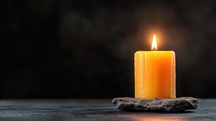 A solitary yellow candle gently flickers in the darkness, symbolizing warmth, hope, and tranquility against a somber backdrop, creating a serene and calming atmosphere.