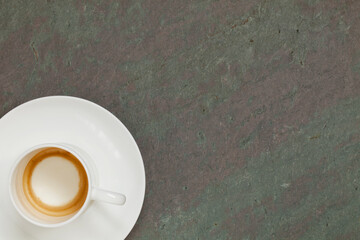 empty white china cup of espresso coffee on slate stone table