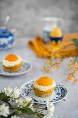 Lemon cupcakes with cream cheese, apricot and poppy seed. Cupcake in form of Fried Egg on a stone background. Easter eggs. Easter holiday and festive food.