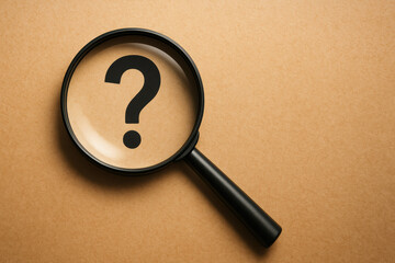 Magnifying glass focusing on question mark seeking answers to curiosities and mysteries with clarity