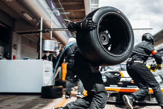 Team Mechanics refuel During a High-Speed Pit Stop in the Midst of an Endurance Race	