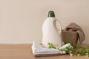 Eco natural household chemicals for home. Bottle with laundry detergent, folded bath towels and...