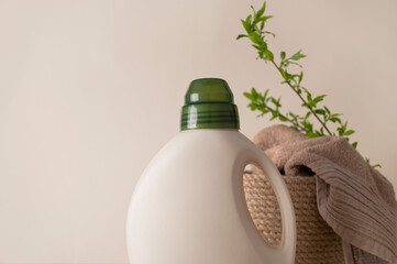 Eco natural household chemicals for home. Bottle with laundry detergent, folded bath towels and...