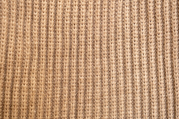knitted texture, beige sweater or carpet. English elastic band pattern. industrial knitting of clothes made of wool, acrylic or cotton. background, knitting.